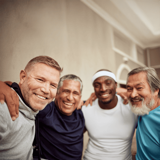 ll-men-image Four diverse men smiling with arms around each other in athletic wear, showing friendship and camaraderie
